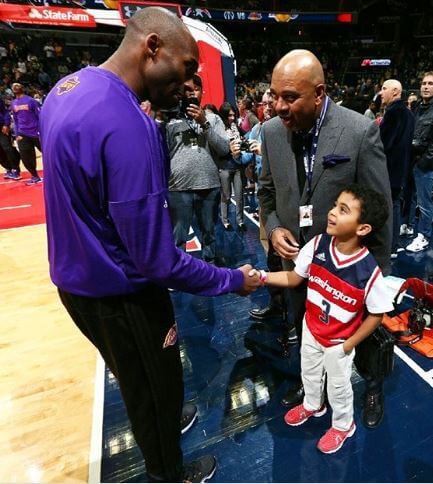 Sheryl Wilbon's son shaking hand with Kobe Bryant.